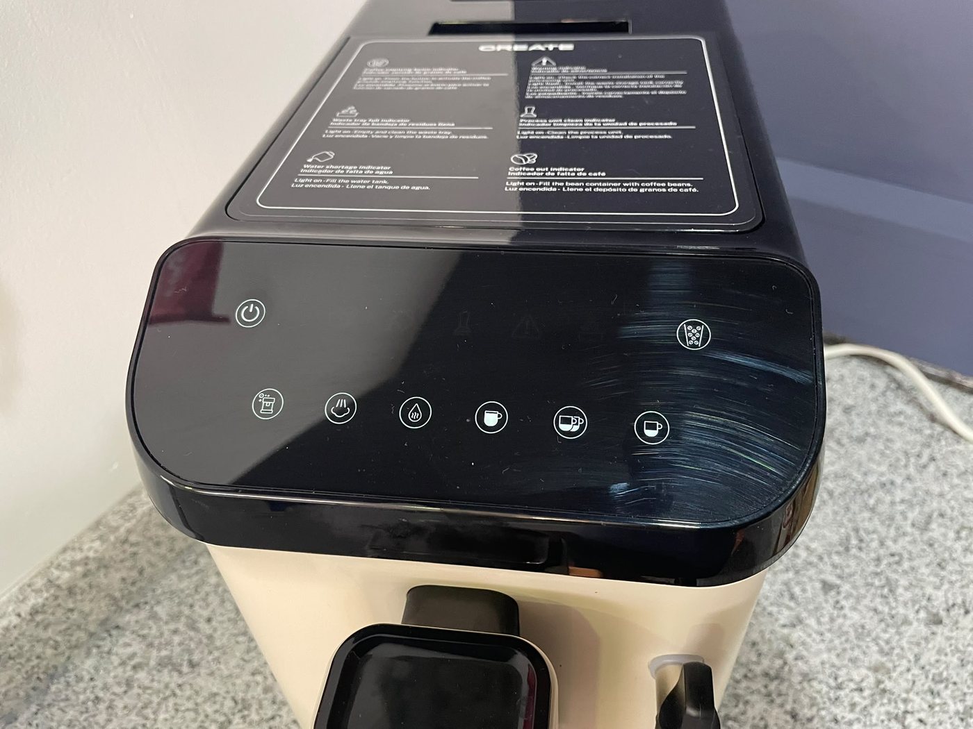 Painel tátil da máquina de café com o botão de ligar no canto superior esquerdo